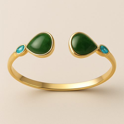 Create a yellow gold cuff with two pear shaped pieces of nephrite jade at the ends and two petite pear shaped blue topaz’s set in the gold of the bracelet