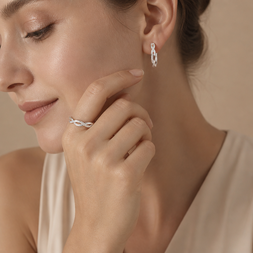 Jewelry photoshoot (worn)
Show the jewelry piece from the image worn by an elegant model in a professional editorial photograph, soft studio lighting. Reproduce the jewelry's exact design, metal, stones and details faithfully. Photorealistic, no text. Additional instructions: "Close-up beauty/editorial photo of a woman's wrist and hand, fair light skin tone, gently relaxed pose (resting on a soft surface or lightly touching her face/collarbone). Soft, warm neutral studio background (beige/cream tones), softly blurred, shallow depth of field.
She wears a delicate sterling silver chain bracelet featuring a small round bezel-set cubic zirconia stone on one side of the chain and a small sideways cross charm on the other side, connected by a fine cable chain.
METAL FINISH: the sterling silver must be rhodium-plated — bright, cool-white, and reflective with a polished mirror-like shine, not dull or matte. The metal should catch light naturally and sparkle realistically, without looking overly glossy, plastic, or artificially glowing.
SKIN REALISM REQUIREMENT: skin must look completely natural and photorealistic — fair, light skin tone to enhance the contrast and shine of the silver, with visible fine skin texture, natural pores, subtle imperfections. Avoid any smooth, plastic, airbrushed, CGI, or overly retouched look. Lighting soft and warm, casting natural gentle shadows.
STRICT SIZE REQUIREMENT: the bracelet must stay true to real-life scale, fine and delicate — the round stone approximately 0.6cm, the cross charm small and slim, both proportionate to the wrist. Do not enlarge or oversize.
BRACELET POSITION: the chain drapes naturally around the wrist, with the round stone and cross charm both visible and facing forward, sitting flat against the skin.
Close-up beauty/editorial photo of a woman's wrist and hand, fair light skin tone, gently relaxed pose (resting on a soft surface or lightly touching her face/collarbone). Soft, warm neutral studio background (beige/cream tones), softly blurred, shallow depth of field.
She wears a delicate sterling silver double-chain bracelet featuring a small infinity symbol charm, partially lined with sparkling pavé cubic zirconia stones on one side, connected by two fine parallel cable chains.
METAL FINISH: the sterling silver must be rhodium-plated — bright, cool-white, and reflective with a polished mirror-like shine, not dull or matte. The metal should catch light naturally and sparkle realistically, without looking overly glossy, plastic, or artificially glowing.
SKIN REALISM REQUIREMENT: skin must look completely natural and photorealistic — fair, light skin tone to enhance the contrast and shine of the silver, with visible fine skin texture, natural pores, subtle imperfections. Avoid any smooth, plastic, airbrushed, CGI, or overly retouched look. Lighting soft and warm, casting natural gentle shadows.
STRICT SIZE REQUIREMENT: the bracelet must stay true to real-life scale, fine and delicate — the infinity charm small and slim, proportionate to the wrist, double chain thin and dainty. Do not enlarge or oversize.
BRACELET POSITION: the double chain drapes naturally around the wrist, with the infinity charm centered and facing forward, sitting flat against the skin.
"Close-up beauty/editorial photo of a woman's wrist and hand, fair light skin tone, gently relaxed pose (resting on a soft surface or lightly touching her face/collarbone). Soft, warm neutral studio background (beige/cream tones), softly blurred, shallow depth of field.
She wears a delicate sterling silver chain bracelet featuring four small round bezel-set cubic zirconia stones evenly spaced along a fine cable chain.
METAL FINISH: the sterling silver must be rhodium-plated — bright, cool-white, and reflective with a polished mirror-like shine, not dull or matte. The metal should catch light naturally and sparkle realistically, without looking overly glossy, plastic, or artificially glowing.
SKIN REALISM REQUIREMENT: skin must look completely natural and photorealistic — fair, light skin tone to enhance the contrast and shine of the silver, with visible fine skin texture, natural pores, subtle imperfections. Avoid any smooth, plastic, airbrushed, CGI, or overly retouched look. Lighting soft and warm, casting natural gentle shadows.
STRICT SIZE REQUIREMENT: the bracelet must stay true to real-life scale, fine and delicate — each round stone approximately 0.5cm, evenly spaced along the thin chain, proportionate to the wrist. Do not enlarge or oversize.
BRACELET POSITION: the chain drapes naturally around the wrist, with all four stones visible and evenly spaced, sitting flat against the skin, catching soft light.
Close-up beauty/editorial photo of a woman's wrist and hand, fair light skin tone, gently relaxed pose (resting on a soft surface or lightly touching her face/collarbone). Soft, warm neutral studio background (beige/cream tones), softly blurred, shallow depth of field.
She wears a delicate sterling silver chain bracelet featuring four small plain polished cross charms dangling evenly along a fine cable chain.
METAL FINISH: the sterling silver must be rhodium-plated — bright, cool-white, and reflective with a polished mirror-like shine, not dull or matte. The metal should catch light naturally and sparkle realistically, without looking overly glossy, plastic, or artificially glowing.
SKIN REALISM REQUIREMENT: skin must look completely natural and photorealistic — fair, light skin tone to enhance the contrast and shine of the silver, with visible fine skin texture, natural pores, subtle imperfections. Avoid any smooth, plastic, airbrushed, CGI, or overly retouched look. Lighting soft and warm, casting natural gentle shadows.
STRICT SIZE REQUIREMENT: the bracelet must stay true to real-life scale, fine and delicate — each cross charm approximately 0.7cm height x 0.5cm width, dangling evenly along the thin chain, proportionate to the wrist. Do not enlarge or oversize.
BRACELET POSITION: the chain drapes naturally around the wrist, with all four cross charms visible and gently dangling, sitting naturally against the skin, catching soft light.
"Close-up beauty/editorial photo of a woman's hand gently resting near her face and jawline, fingers relaxed and slightly curled, showing the finger clearly. Soft, warm neutral studio background (beige/cream tones), softly blurred, shallow depth of field.
She wears a sterling silver twisted infinity open cuff ring, featuring an interwoven double-band design where one smooth polished band crosses over a second band fully lined with sparkling pavé cubic zirconia stones, forming a twisted braid-like pattern.
METAL FINISH: the sterling silver must be rhodium-plated — bright, cool-white, and reflective with a polished mirror-like shine, not dull or matte. The metal should catch light naturally and sparkle realistically, without looking overly glossy, plastic, or artificially glowing.
SKIN REALISM REQUIREMENT: skin must look completely natural and photorealistic — visible fine skin texture, natural pores, subtle imperfections, soft even tone, natural nails. Avoid any smooth, plastic, airbrushed, CGI, or overly retouched look. Lighting soft and warm, casting natural gentle shadows.
STRICT SIZE REQUIREMENT: the ring must stay true to real-life scale, delicate and slim, not bulky or oversized — the twisted pavé band proportionate to the finger.
RING POSITION: the ring sits naturally centered on the finger, open twisted band facing forward and clearly visible, catching soft light along the pavé stones.
"Close-up beauty/editorial photo of a woman's hand gently resting near her face and jawline, fingers relaxed and slightly curled, with her ear also visible and exposed (hair pulled back or tucked behind the ear). Head gently turned to show both the hand and the ear clearly in frame. Soft, warm neutral studio background (beige/cream tones), softly blurred, shallow depth of field.
She wears a sterling silver twisted infinity open cuff ring on her finger, and a matching sterling silver twisted infinity hoop earring, both featuring the same interwoven double-band design — one smooth polished band crossing over a second band fully lined with sparkling pavé cubic zirconia stones, forming a twisted braid-like pattern.
METAL FINISH: the sterling silver must be rhodium-plated — bright, cool-white, and reflective with a polished mirror-like shine, not dull or matte. The metal should catch light naturally and sparkle realistically, without looking overly glossy, plastic, or artificially glowing.
SKIN REALISM REQUIREMENT: skin must look completely natural and photorealistic — visible fine skin texture, natural pores, subtle imperfections, soft even tone, natural nails. Avoid any smooth, plastic, airbrushed, CGI, or overly retouched look. Lighting soft and warm, casting natural gentle shadows.
STRICT SIZE REQUIREMENT: both pieces must be true to real-life scale, not oversized. The ring sits naturally on the finger, delicate and slim, not bulky. The hoop earring must be exactly 1.4cm height x 0.3cm band width — small and delicate against the ear, sitting closely against the earlobe.
JEWELRY POSITION: the ring sits naturally centered on the finger with the open twisted band clearly visible; the earring hangs through the earlobe with the twisted pavé pattern facing forward, clearly visible. Both pieces must be sharply in focus and easy to see in the frame.
Mood: elegant, minimal, intimate — high-end jewelry brand photography style, sharp focus on both the ring and earring while keeping the composition natural and soft.".