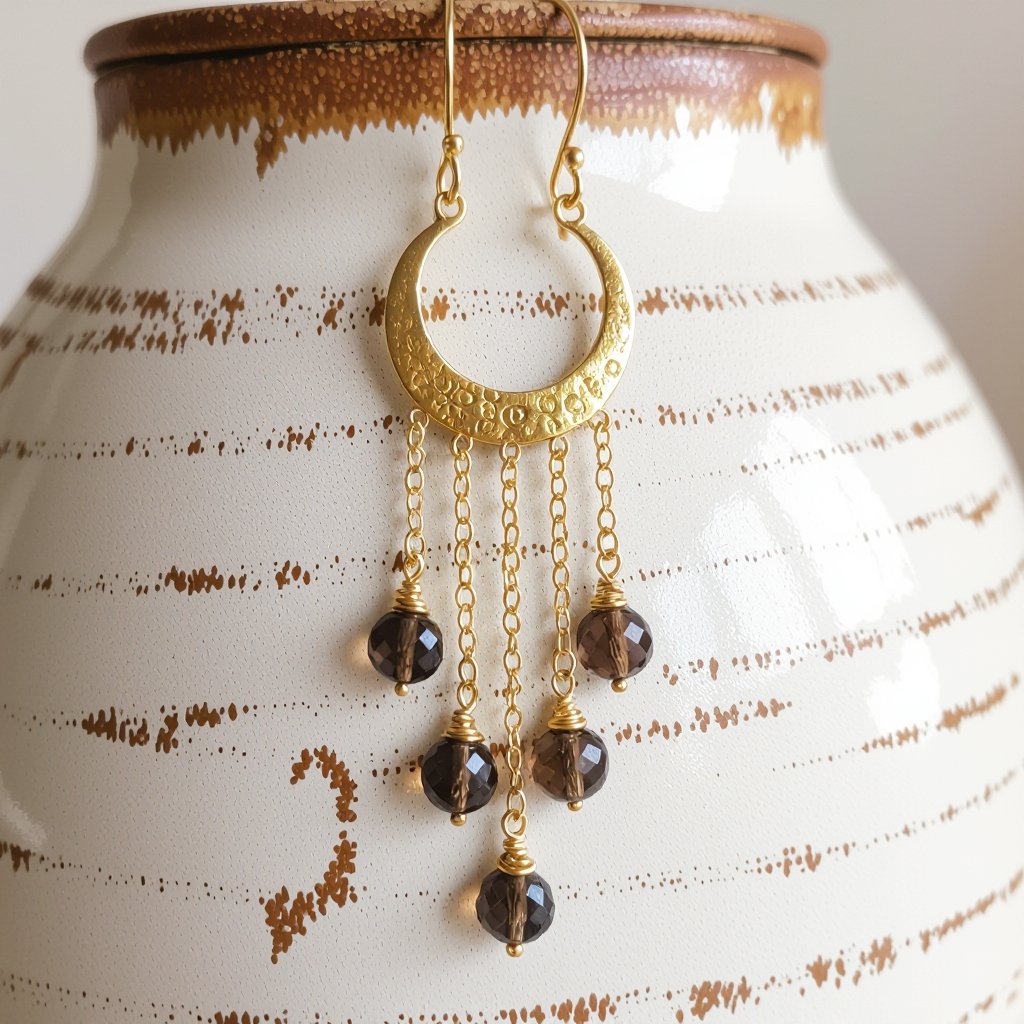 Золотые серьги полумесяц вертикальный 2 см, сверху крепится к швензе. От полумесяца идет три цепочки золотого цвета, у каждой на конце камушек раухтопаз