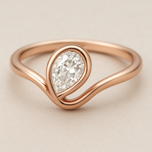 A delicate rose gold pinky ring featuring a 0.50-carat pear-shaped diamond set in a smooth bezel setting. The diamond is gently tilted to the left, creating a soft paisley-inspired curve that radiates feminine Yin energy — graceful, flowing, intuitive, and serene. The polished rose gold band enhances the gentle movement and balance of the design, symbolizing elegance, emotional depth, and the beauty of lunar energy.  
