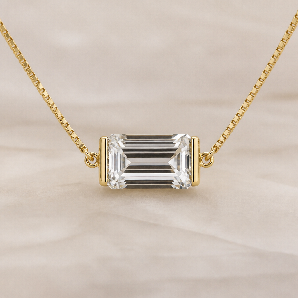 A 10ct clear emerald cut diamond with half bezel. The bezel is only on the left and right sides of the diamond. The diamond is east west on a thin box chain. All of the metal is yellow gold. The bezel connects to the pendant in the middle of the diamond, not the top corners
photorealistic jewelry design, A 10ct clear emerald cut diamond with half bezel. The bezel is only on the left and right sides of the diamond. The diamond is east west on a thin box chain. All of the metal is yellow gold. The bezel connects to the pendant in the middle of the diamond, not the top corners , minimalist style, just the design no text