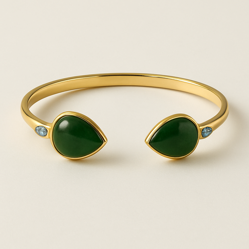 Create a yellow gold cuff with two pear shaped pieces of nephrite jade at the ends and two petite pear shaped blue topaz’s set in the gold of the bracelet