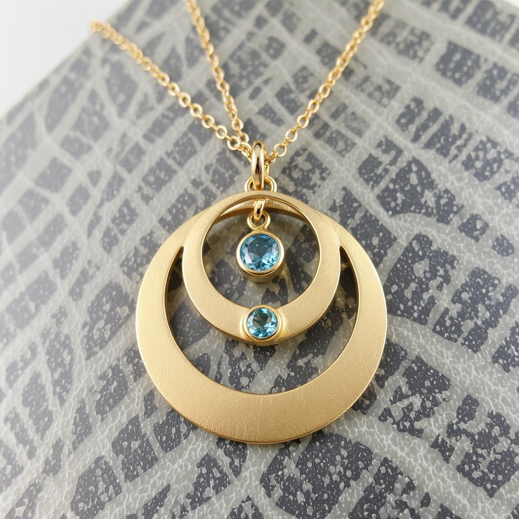 Подвеска из трех полумесяцев с узорами и камнями раухтопаза из матового неровного светлого золота с узорами соединенных цепочкой сверху самый широкий полукруг дальше средний и снизу самый маленький