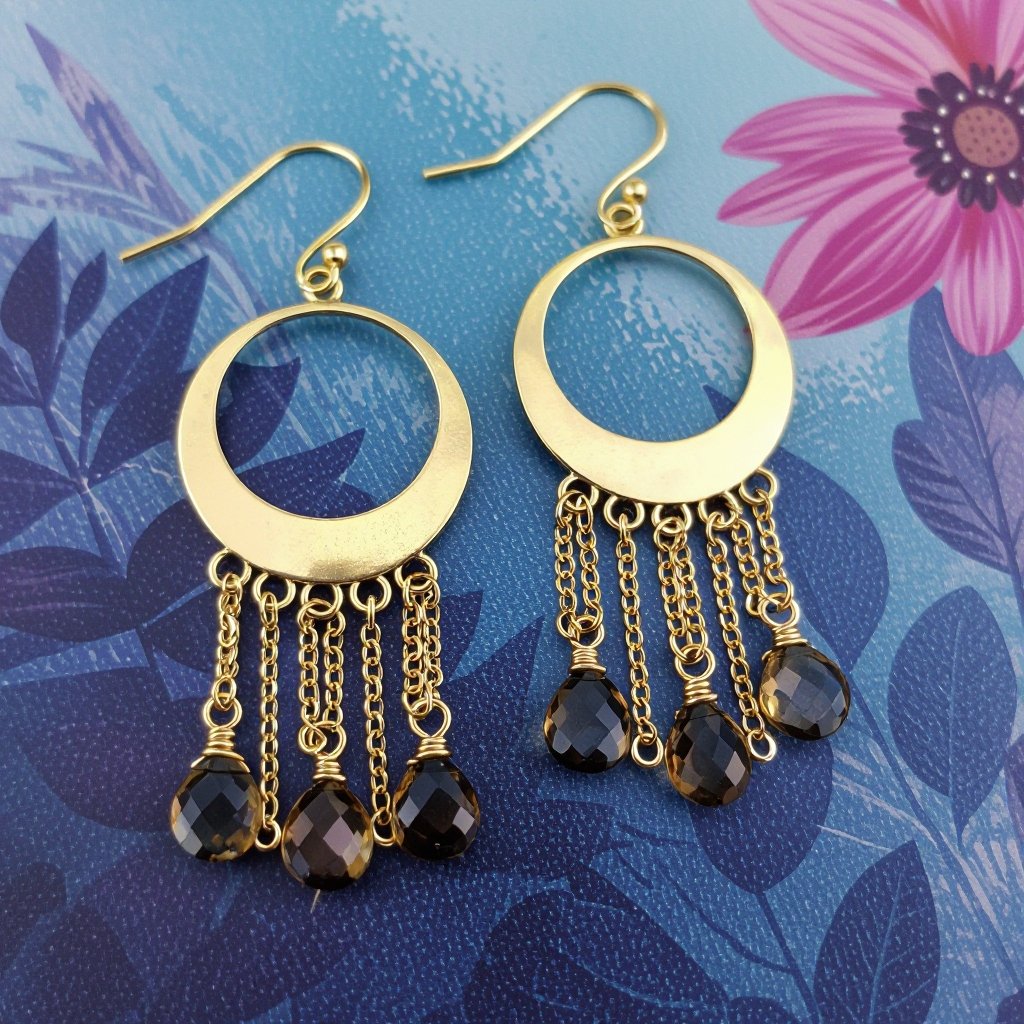 Золотые серьги полумесяц вертикальный 2 см, сверху крепится к швензе. От полумесяца идет три цепочки золотого цвета, у каждой на конце камушек раухтопаз