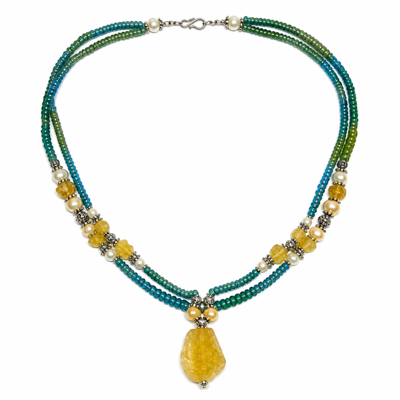 A tribal women's necklace suitable for daily wear. black lines represent triple strand of seed beads (green to blue) with silver representing larger yellow to white beads. Focal bead is the rough cut yellow carp.
using the attached image as a visual reference, create A tribal women's necklace suitable for daily wear. black lines represent triple strand of seed beads (green to blue) with silver representing larger yellow to white beads. Focal bead is the rough cut yellow carp.. photorealistic, just the design no text