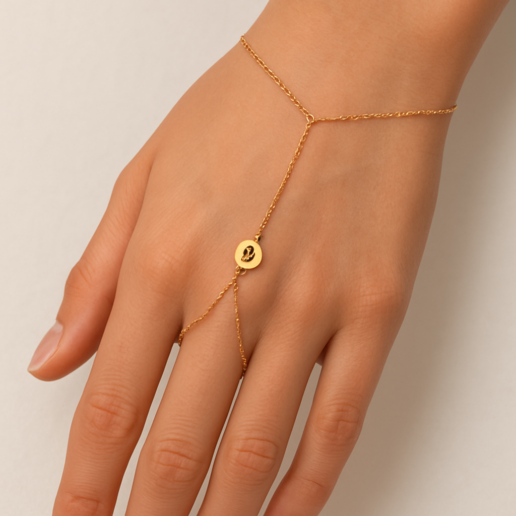 Dainty gold hand chain with 2 chains on wrist with a very small ₿ symbol