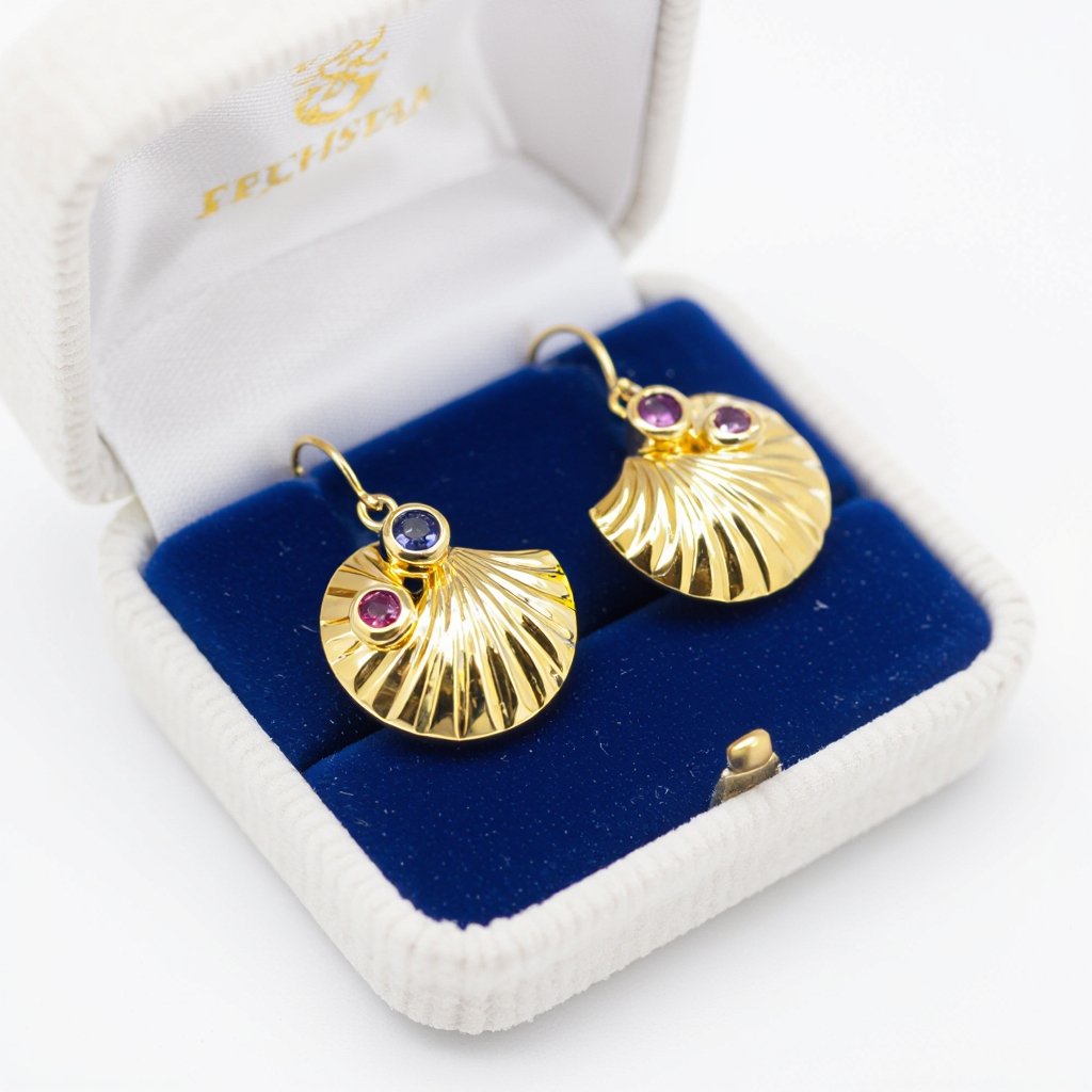 Золотые серьги в виде золотой спиральной ракушки украшенной тремя маленькими камнями 