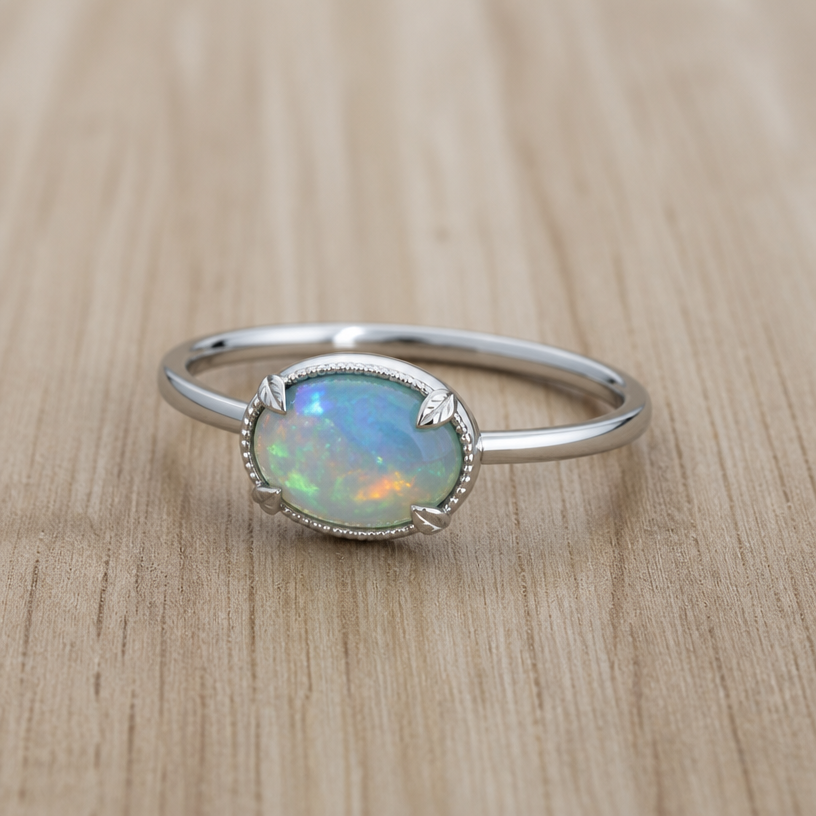 A women's ring made of silver, minimalist, simple and delicate, clean lines. the opal in the picture with leaf shape prongs and something around the bezel
using the attached image as a visual reference, create A women's ring made of silver, minimalist, simple and delicate, clean lines. the opal in the picture with leaf shape prongs and something around the bezel. photorealistic, just the design no text