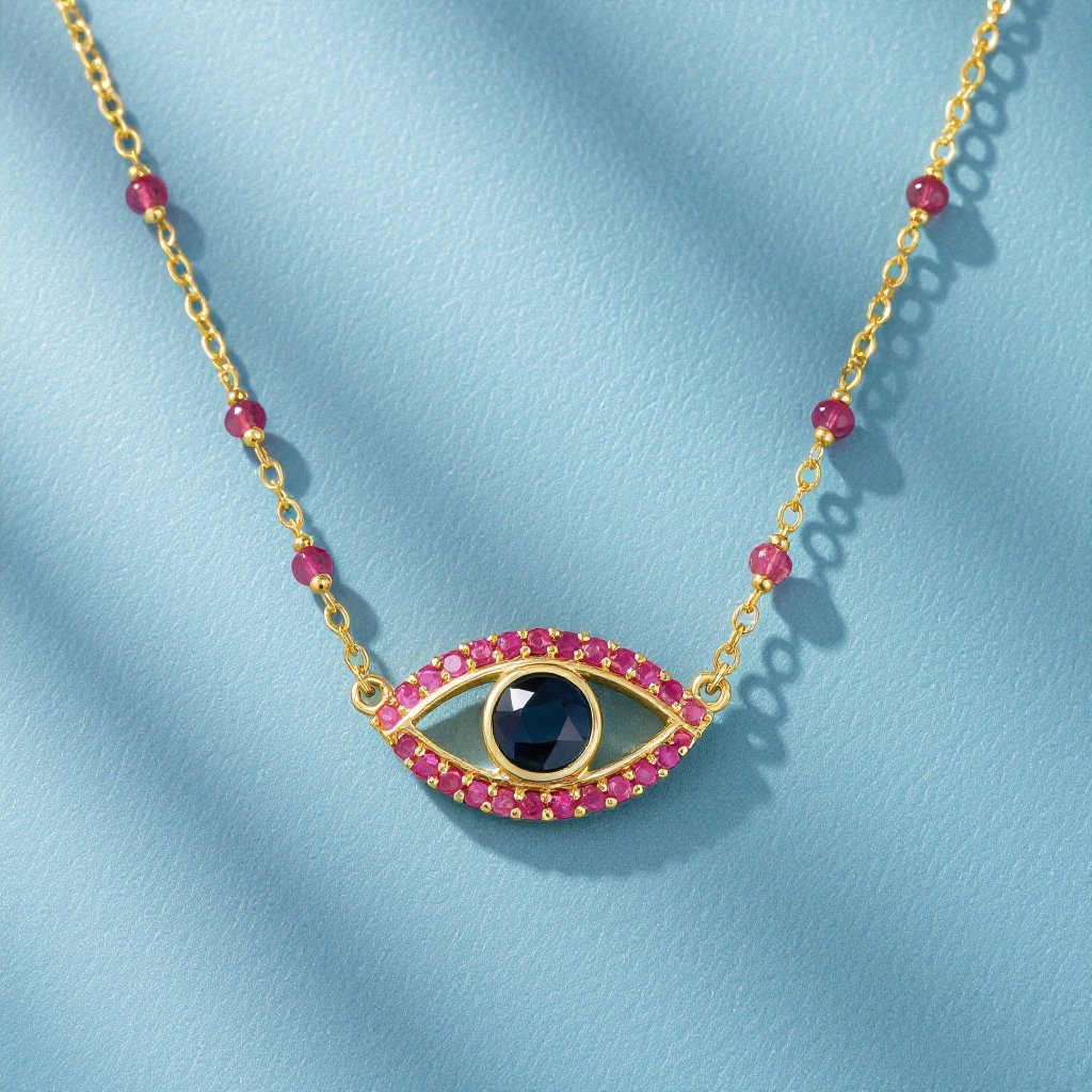 Тонкая цепочка с золотыми шариками и мелкими розовыми камушками на цепочке есть кулон в форме глаза, зрачок глаза из темно синего камня 