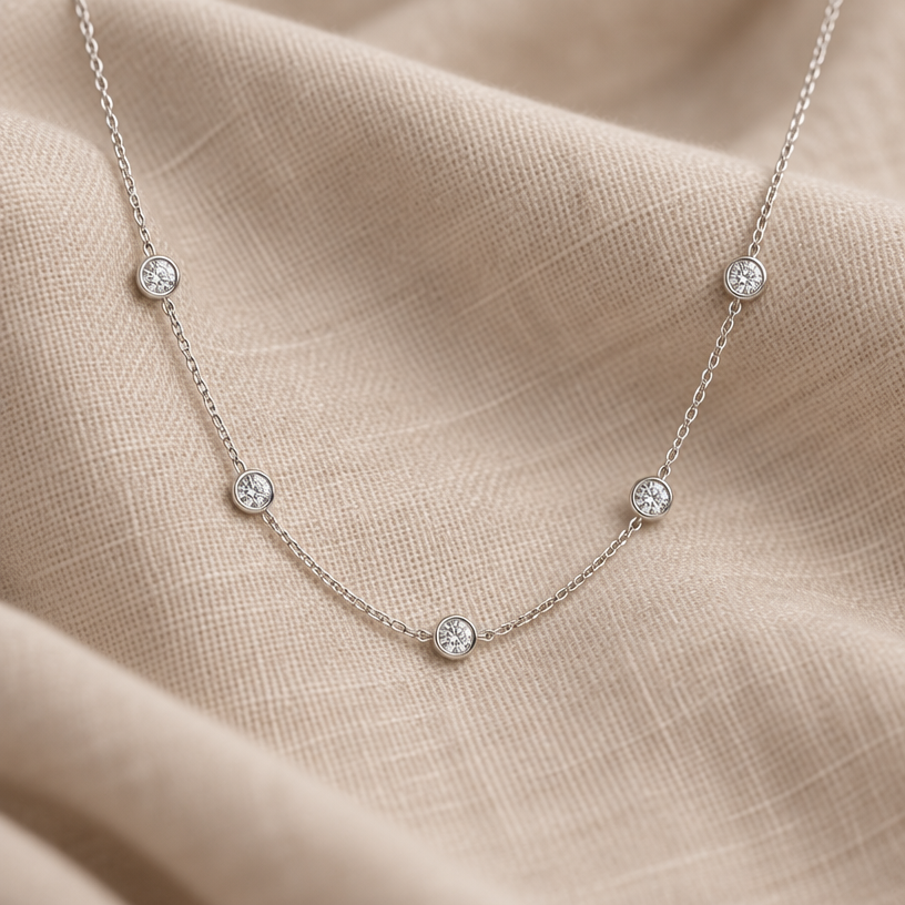 Jewelry photoshoot (worn)
Show the jewelry piece from the image worn by an elegant model in a professional editorial photograph, soft studio lighting. Reproduce the jewelry's exact design, metal, stones and details faithfully. Photorealistic, no text. Additional instructions: "Photorealistic product photography, top-down or slightly angled close-up shot of a delicate minimalist necklace with small graduated diamond stones, elegantly draped on a soft neutral beige linen fabric with gentle natural folds. Soft, diffused studio lighting creates subtle shadows and highlights the sparkle of the stones and the fine detail of the chain. Minimalist warm beige background, shallow depth of field, sharp focus on the necklace, soft blur on the fabric edges. Clean, high-end jewelry catalog aesthetic, 8k resolution, cinematic quality, no text, no logo, no model, no hands.
Jewelry scale note: the necklace and stones must be small, delicate and realistically proportioned — not oversized or exaggerated, true to how fine jewelry actually looks in real life.".