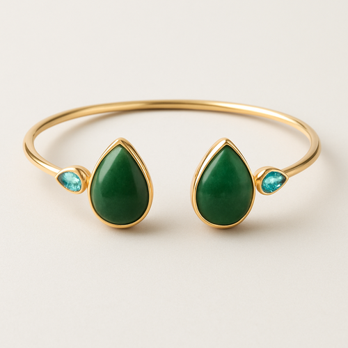 Create a yellow gold cuff with two pear shaped pieces of nephrite jade at the ends and two petite pear shaped blue topaz’s set in the gold of the bracelet