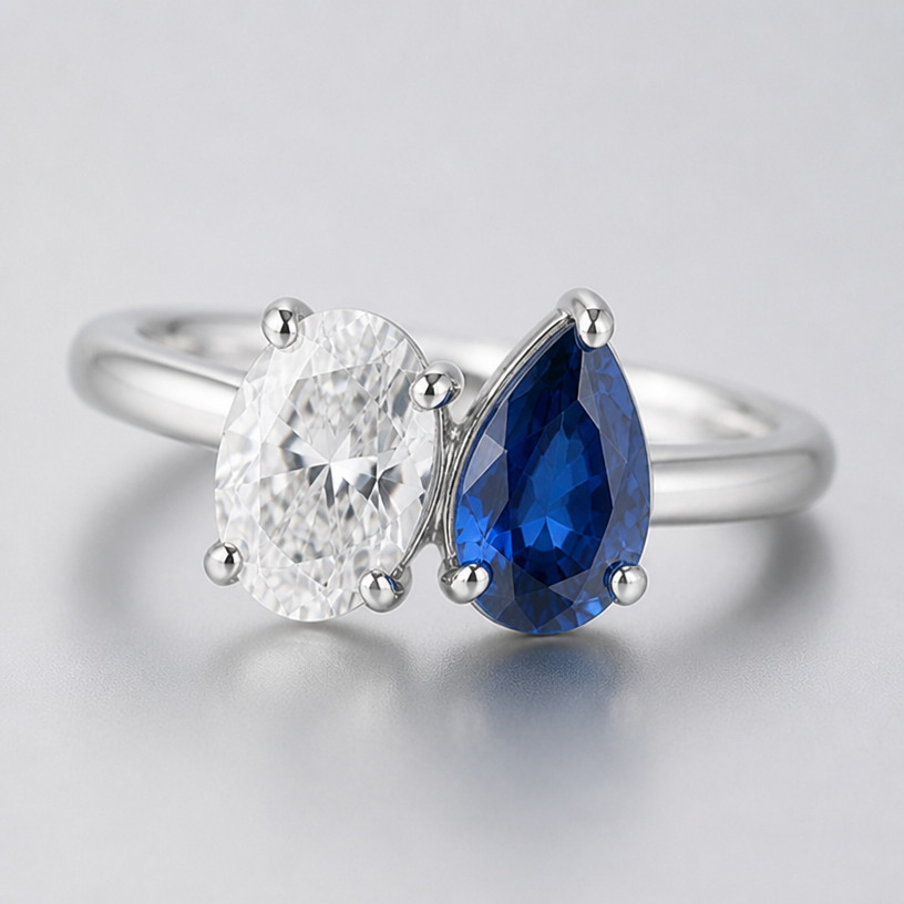 A sterling silver ring toi et moi style. Two stones. 1.46 carat oval white clear diamond on the left and 1.61 carat pear cut blue sapphire on the right. The stones are angled instead of straight up and down
edit the attached jewelry design with these instructions: A sterling silver ring toi et moi style. Two stones. 1.46 carat oval white clear diamond on the left and 1.61 carat pear cut blue sapphire on the right. The stones are angled instead of straight up and down. keep it photorealistic, just the design no text