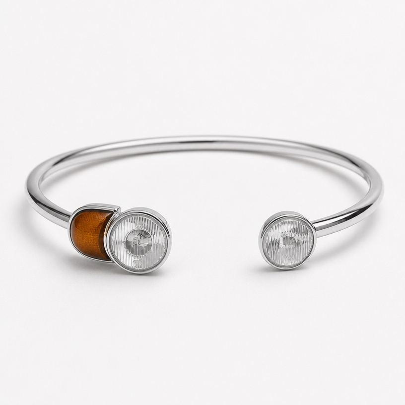 A women's bracelet made of silver, minimalist, simple and delicate, clean lines. a cuff with both ends looking that car lights the two circular one are crystals and the red one is brown agate
using the attached image as a visual reference, create A women's bracelet made of silver, minimalist, simple and delicate, clean lines. a cuff with both ends looking that car lights the two circular one are crystals and the red one is brown agate. photorealistic, just the design no text