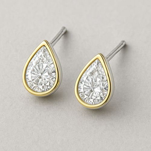 A pear shaped lab grown diamond eraings in white gold a gold borders minimal design