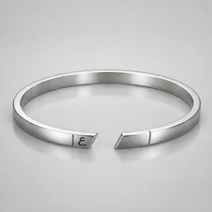 A men's bracelet made of silver. put ء in the left side between the line and the tip or end of the cuff
using the attached image as a visual reference, create A men's bracelet made of silver. put ء in the left side between the line and the tip or end of the cuff. photorealistic, just the design no text