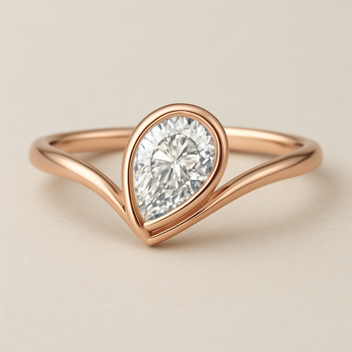 A refined 0.50 diamond  and elegant rose gold ring featuring a pear-shaped diamond set in a smooth bezel setting. The diamond is tilted slightly to the side, creating a paisley-inspired shape reminiscent of a graceful flowing droplet. The rose gold band is sleek and polished, complementing the organic, curving silhouette of the stone. The design blends modern minimalism with a subtle artistic twist inspired by the Bandana paisley motif.