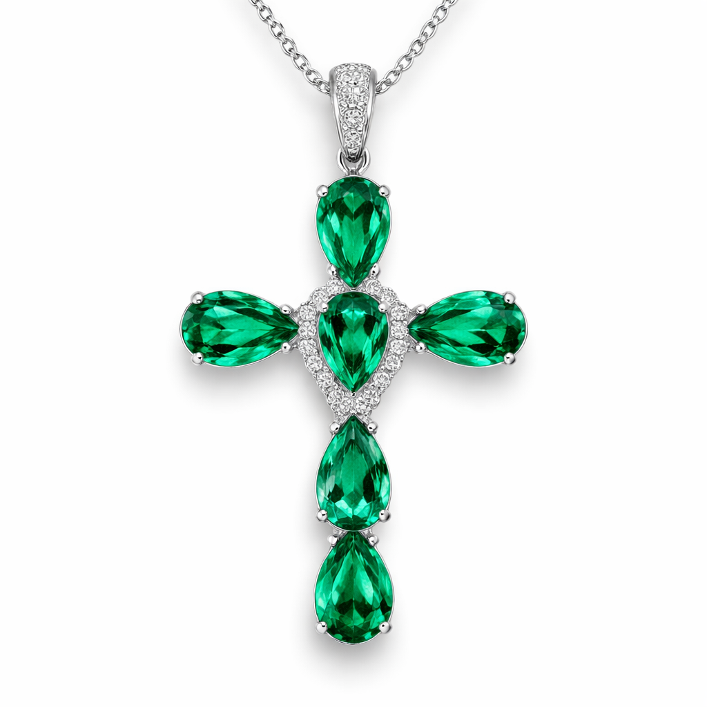 Pear cut Emerald Cross in white gold. Classic and stunning. A few accent diamonds.