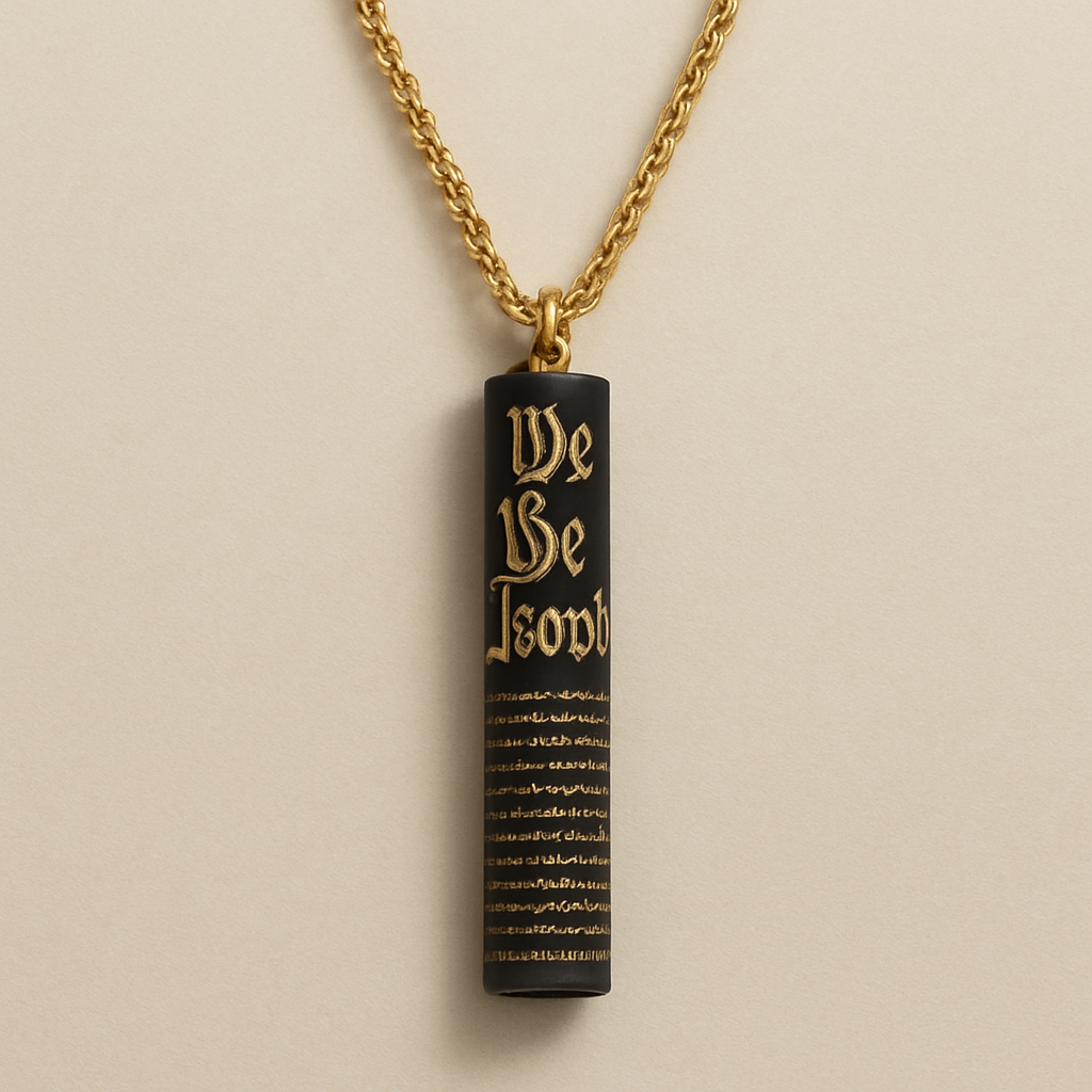 A necklace on a 24” staggered chain with a vertical pendant straw (cylinder) 4 inches long that looks like a rolled up version of the United States constitution “We The People” can be read and is indented as well as the rolled up paper lines. It is black with gold writing. 